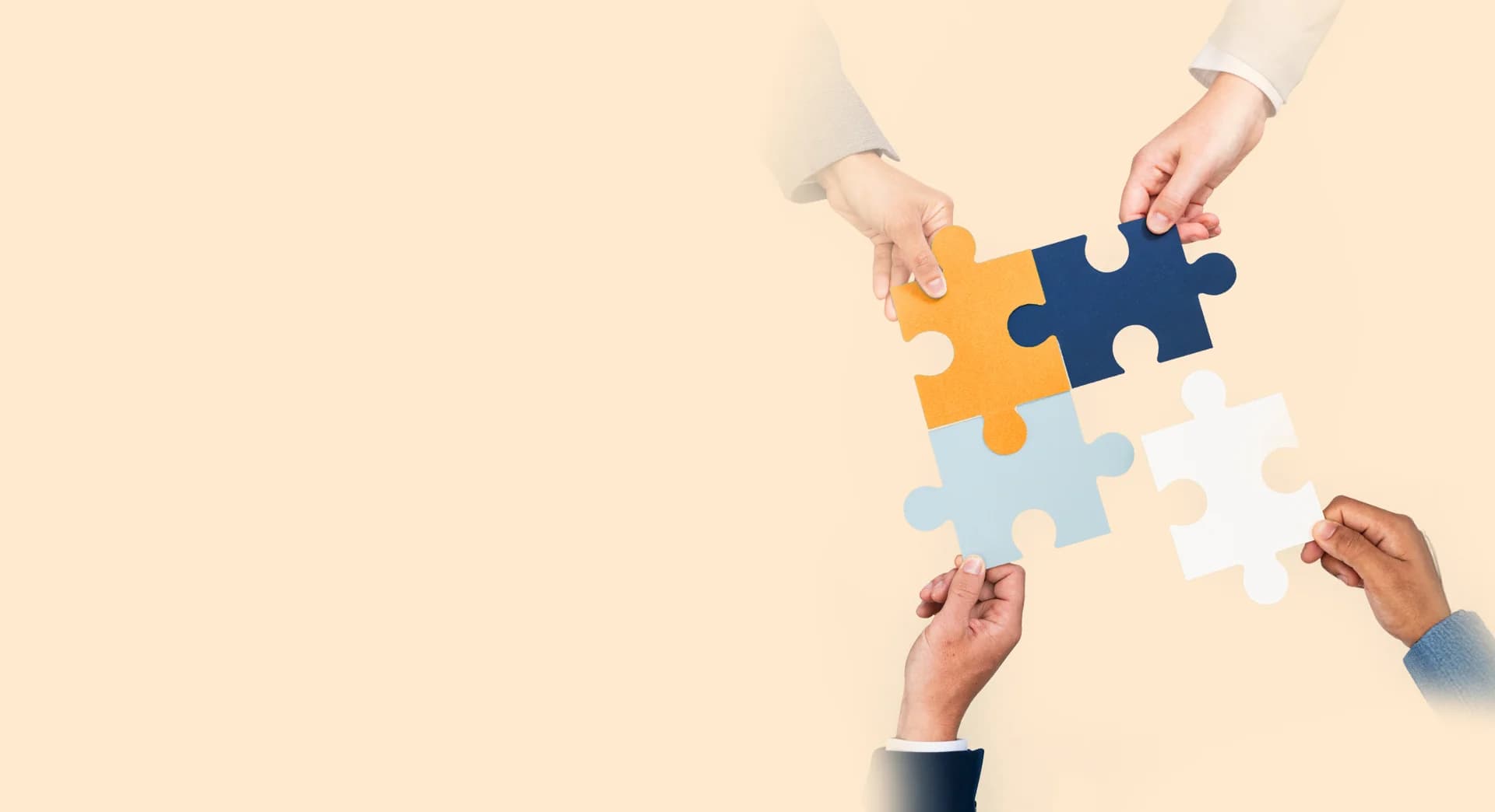 Four hands assembling colourful puzzle pieces